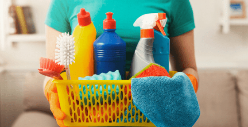 Woman in green shirt gholding basket of cleaning products
